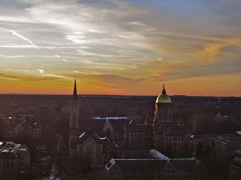 해 질 녘 노터데임 캠퍼스의 대성당 첨탑과 황금 돔